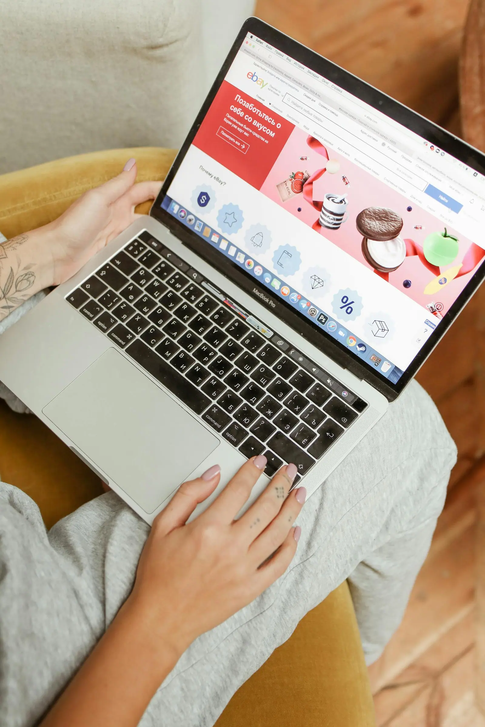 A woman sits comfortably indoors browsing an online shopping website on her laptop