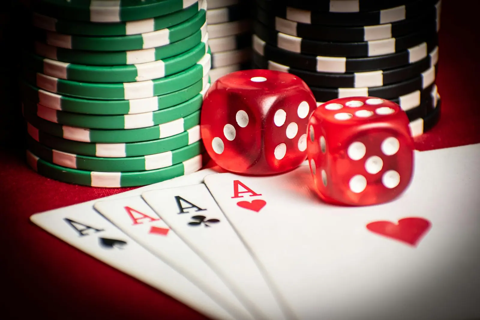 Close up of poker hand with dice and chips symbolizing casino gaming