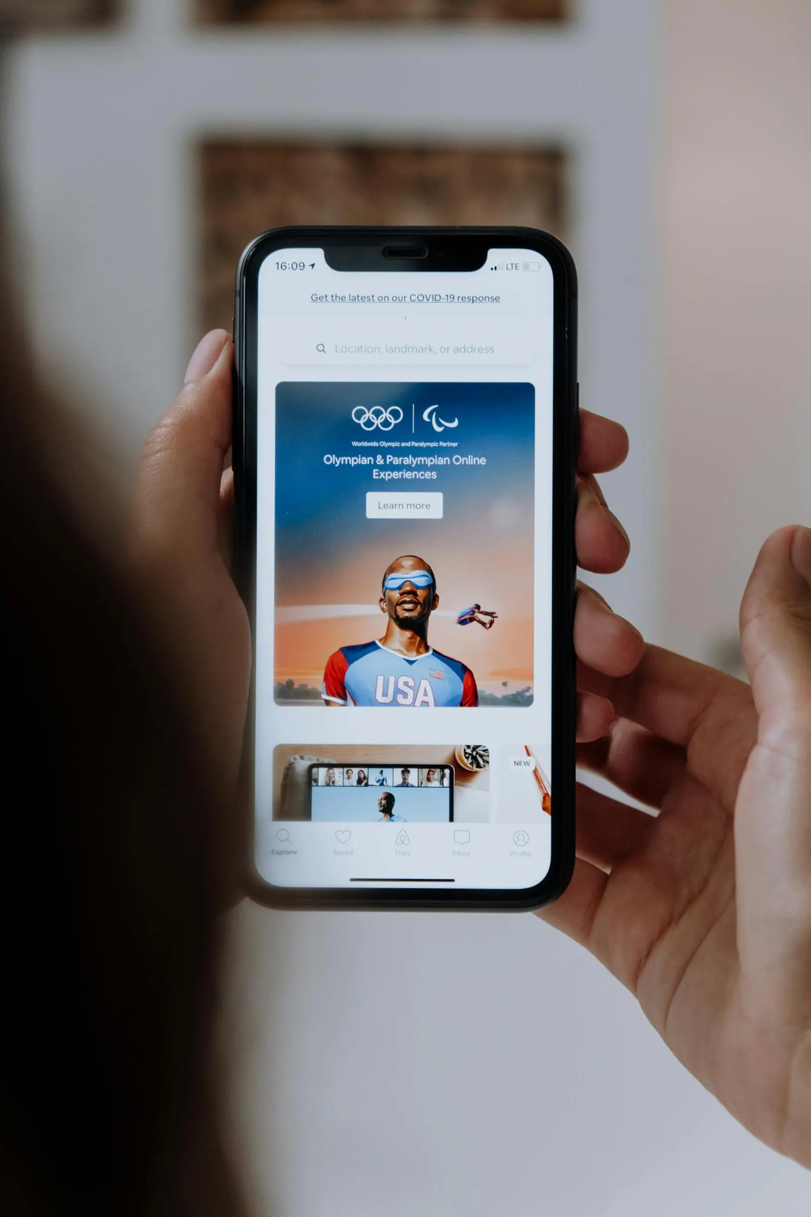 Person holding a smartphone showing olympic and paralympic online experiences