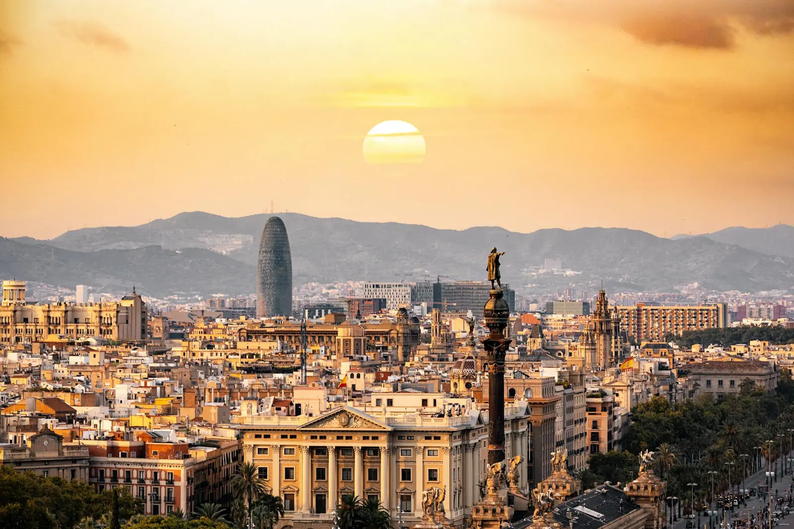 A stunning sunset view of the barcelona skyline showcasing iconic landmarks and a warm golden hour glow