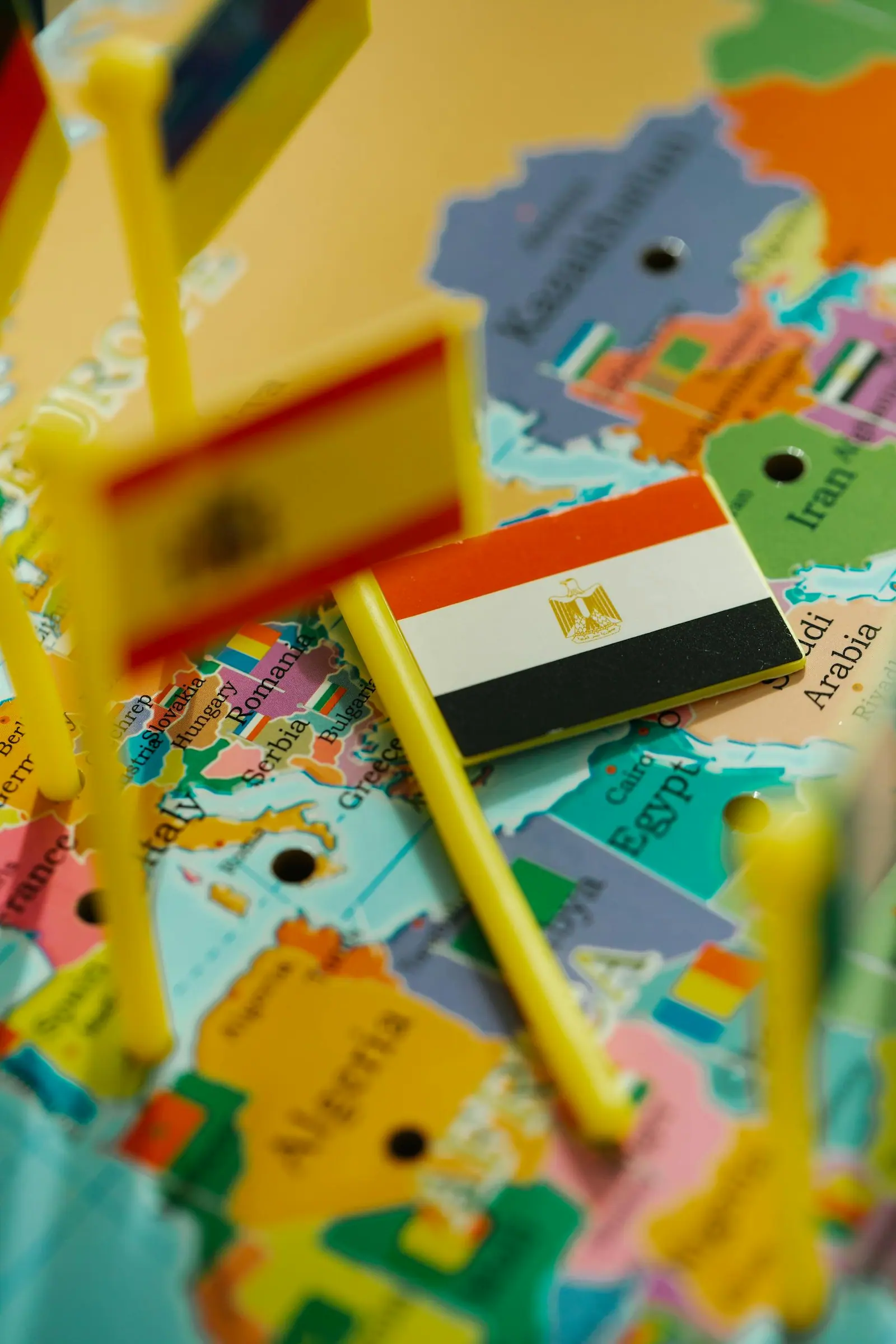Close up of a vibrant map with miniature flags highlighting countries