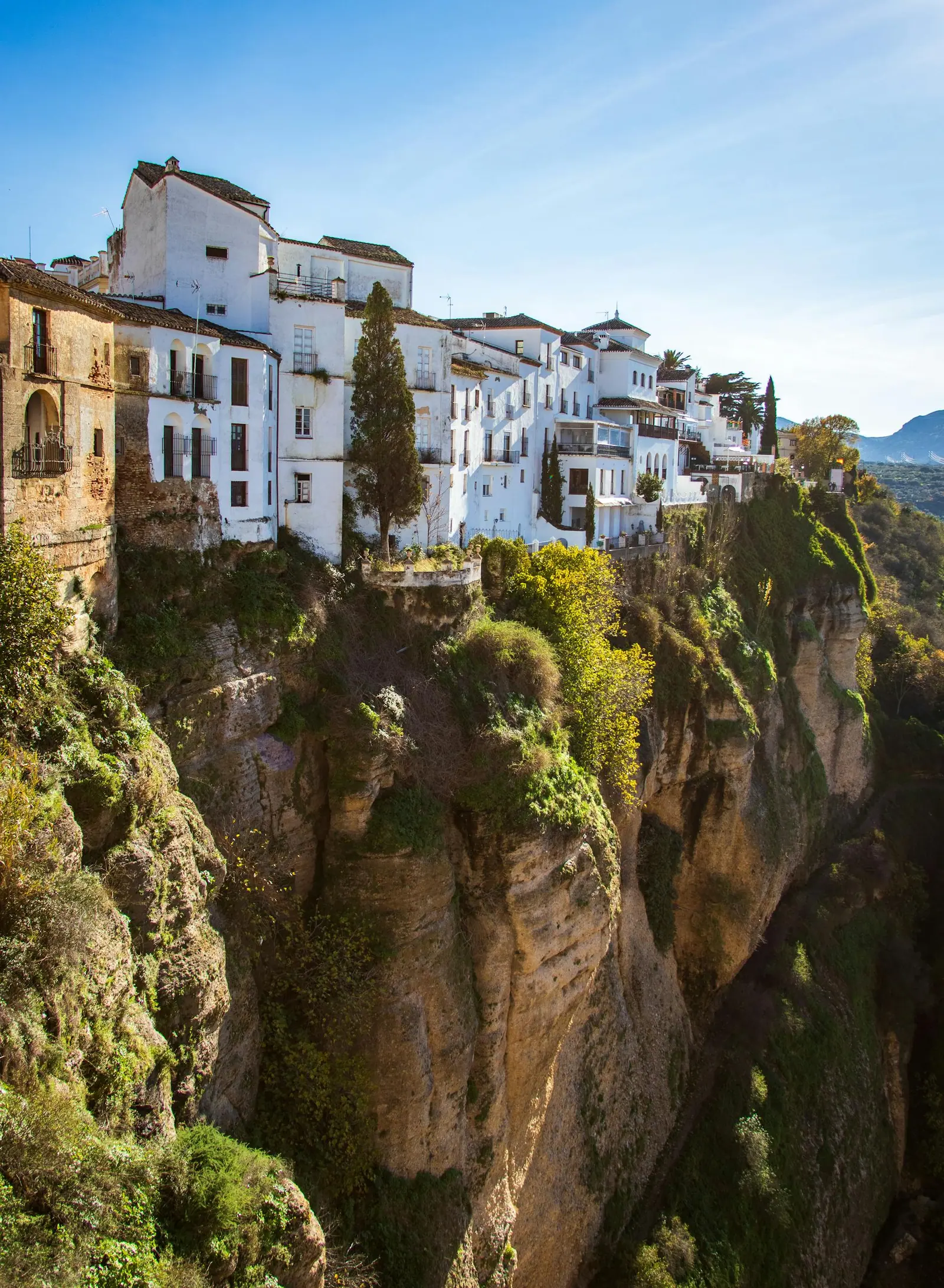 Scenic view of Ronda's historic cliffside buildings in Spain, surrounded by natural beauty.