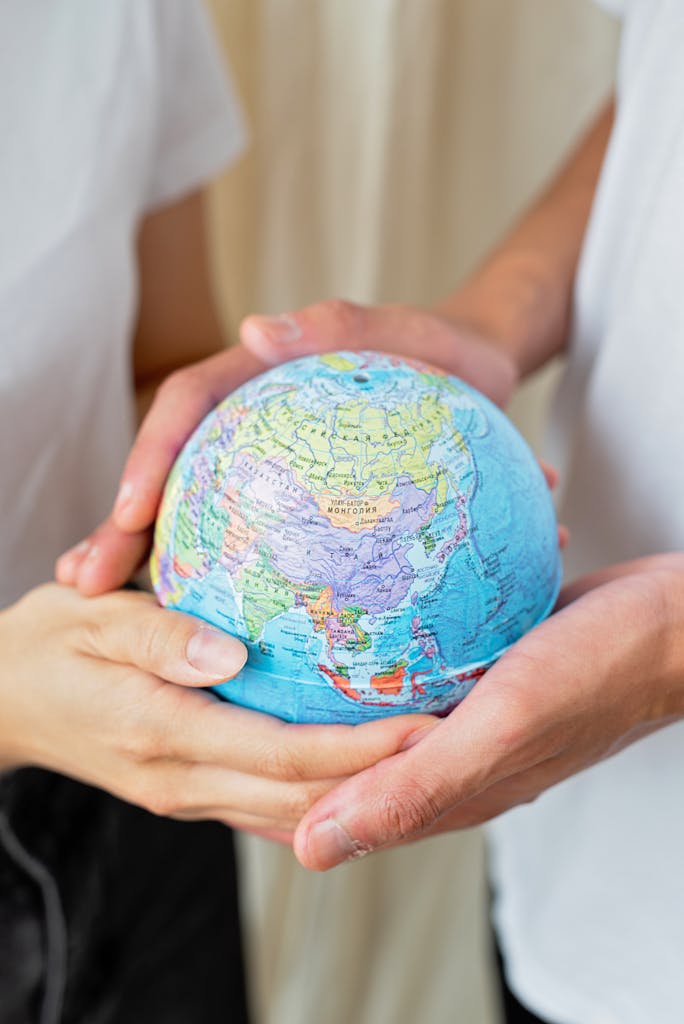 Two adults holding a colorful globe in their hands, representing global unity and environmental awareness.